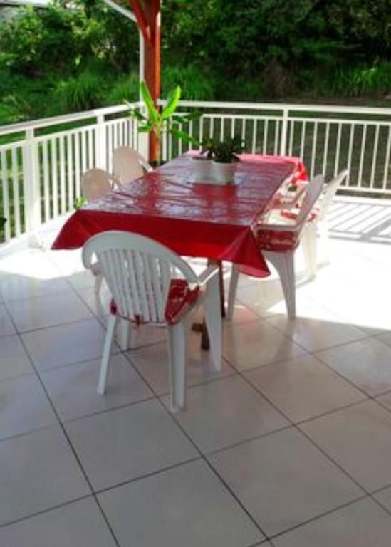 a red table and chairs on a patio at Maison de 2 chambres avec vue sur la mer jardin amenage et wifi a Vieux Habitants a 2 km de la plage in Vieux-Habitants