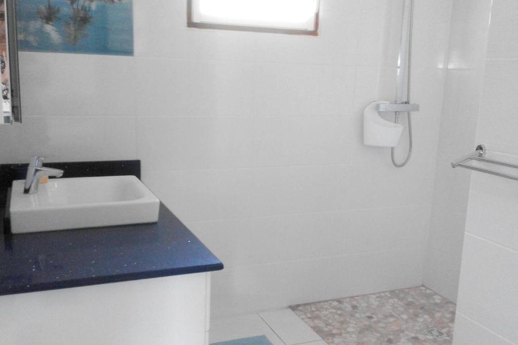 a white bathroom with a sink and a shower at Maison de 2 chambres avec vue sur la mer jardin amenage et wifi a Vieux Habitants a 2 km de la plage in Vieux-Habitants