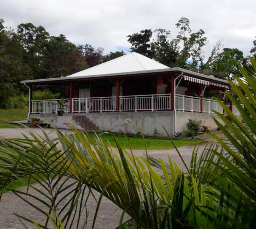 a large house with a red and white porch at Maison de 2 chambres avec vue sur la mer jardin amenage et wifi a Vieux Habitants a 2 km de la plage in Vieux-Habitants