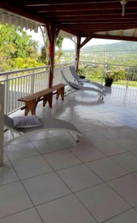 a wooden bench sitting on a porch with a railing at Maison de 2 chambres avec vue sur la mer jardin amenage et wifi a Vieux Habitants a 2 km de la plage in Vieux-Habitants