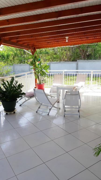 a patio with two chairs and a table on a patio at Maison de 2 chambres avec vue sur la mer jardin amenage et wifi a Vieux Habitants a 2 km de la plage in Vieux-Habitants