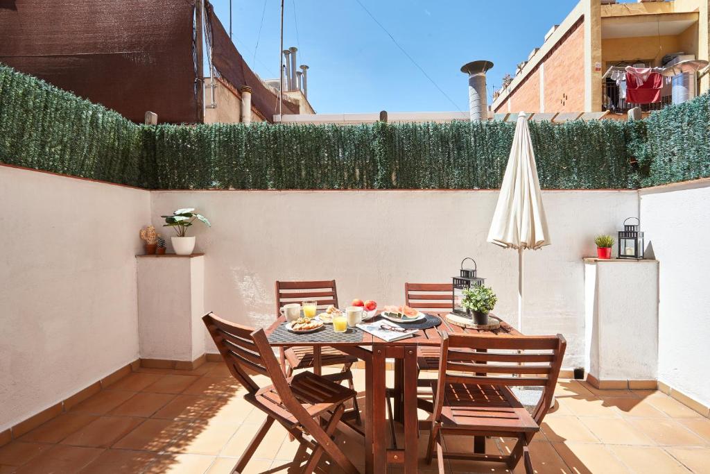 a table and chairs on a patio with an umbrella at BBarcelona Sagrada Familia Terrace Flat in Barcelona