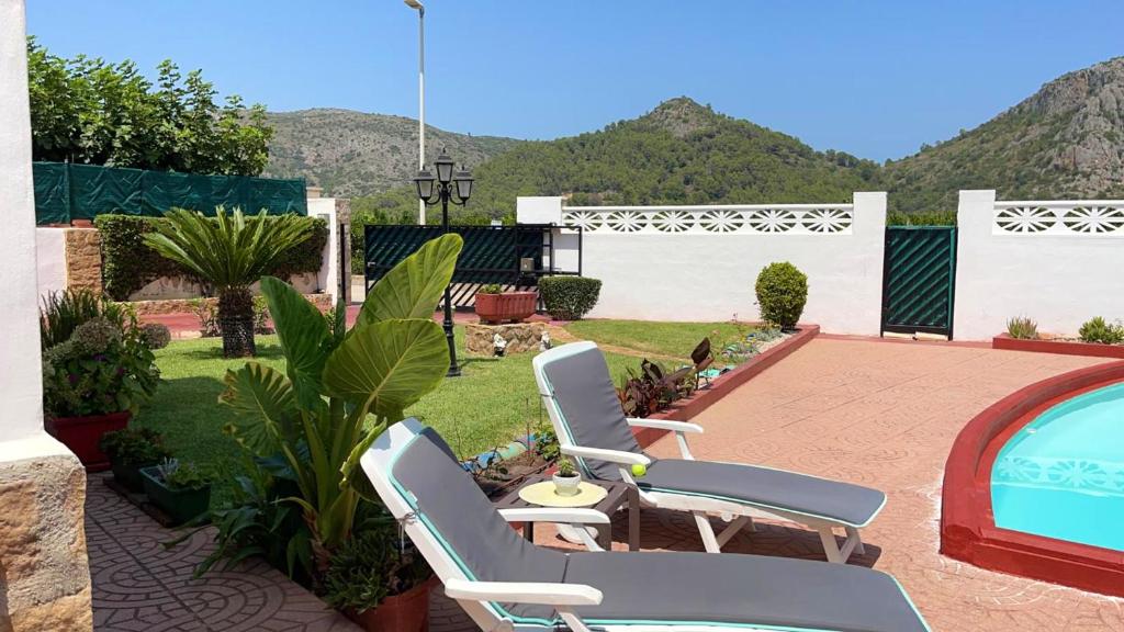 a patio with two chairs and a swimming pool at 3 bedrooms villa with private pool enclosed garden and wifi at Valencia in Marchuquera
