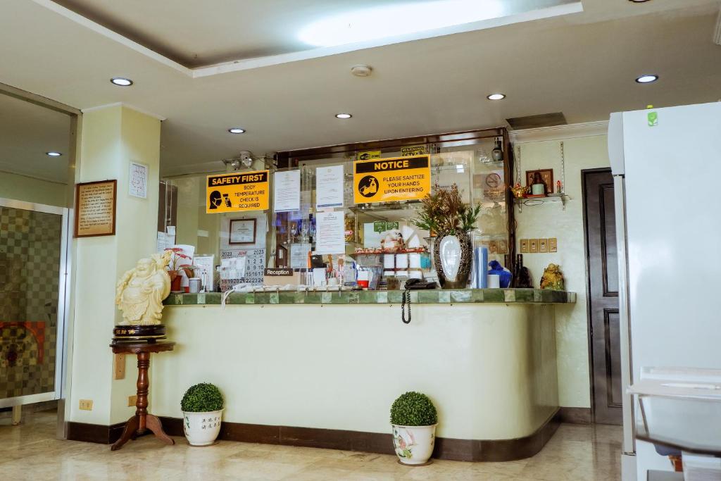 un restaurant avec un comptoir avec des panneaux sur le mur dans l'établissement Hotel Juliano, à Manille