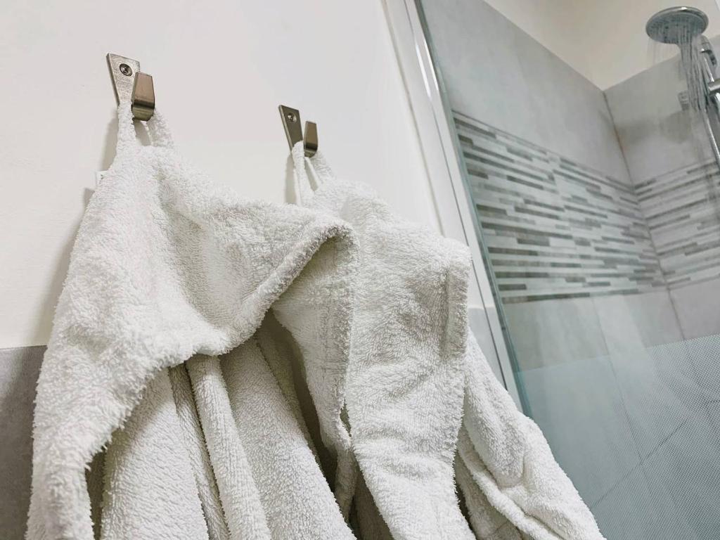 y baño con ducha y toallas blancas. en Attico Elena - Catania, en Catania