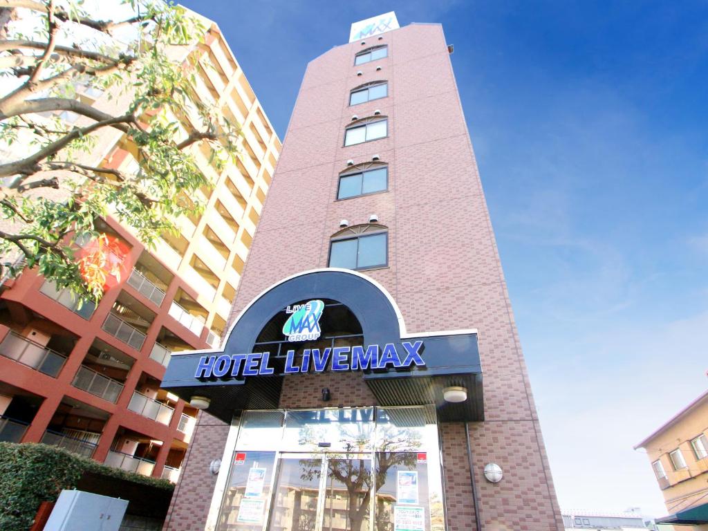 un edificio alto con un signo de Livermology de hotel en él en HOTEL LiVEMAX Kitafuchu, en Fuchu