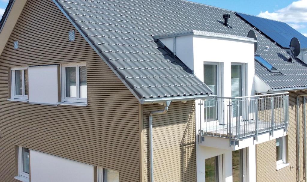 ein Haus mit Metalldach und Balkon in der Unterkunft Casa53N in Seevetal