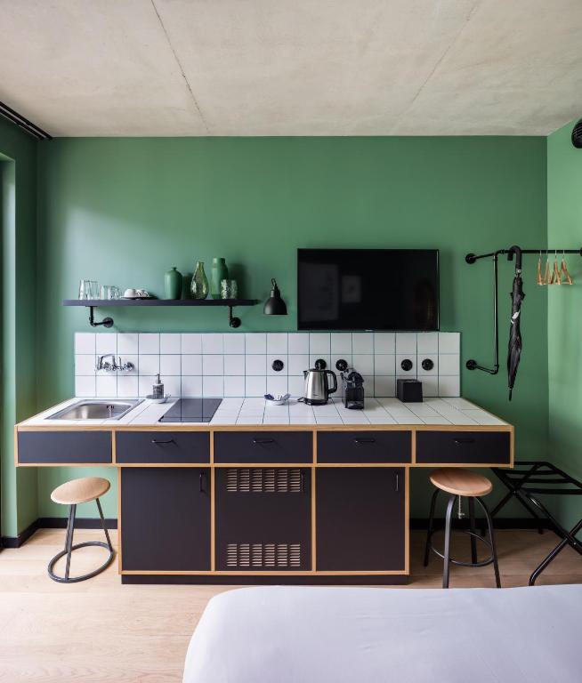 a kitchen with green walls and a counter with a sink at Deskopolitan House in Paris