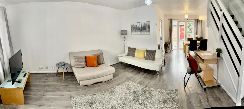 a living room with a couch and a tv at The Herald House Dartford 3 Bedroom Apartment in Kent