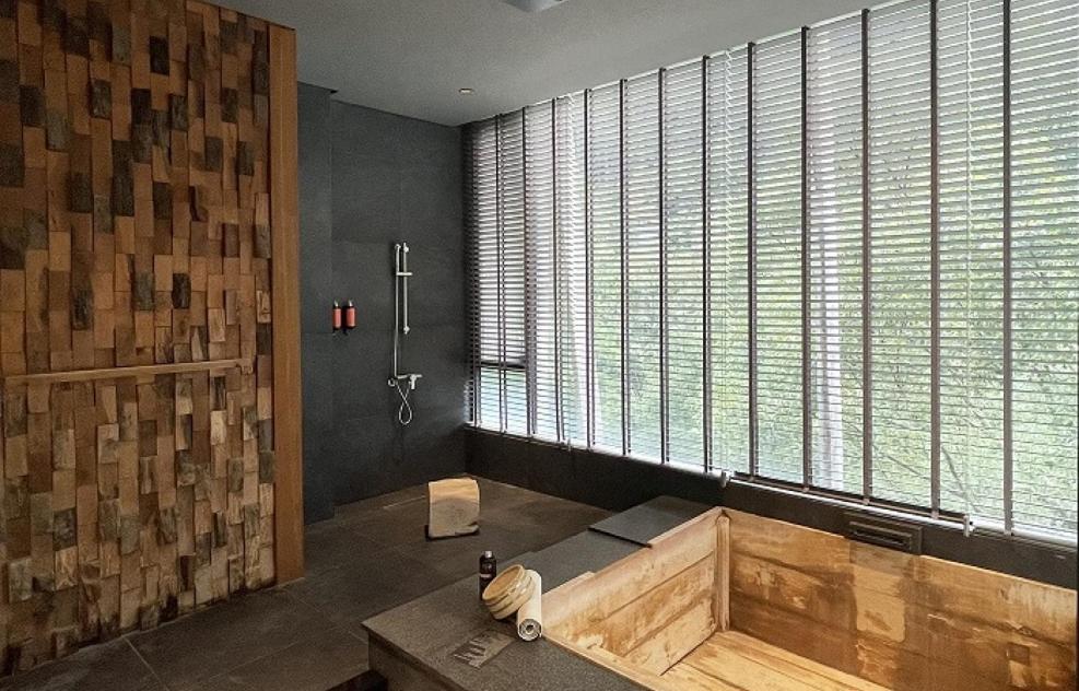 a bathroom with a wooden tub and a large window at Onsen Papawaqa in Tai&#39;an