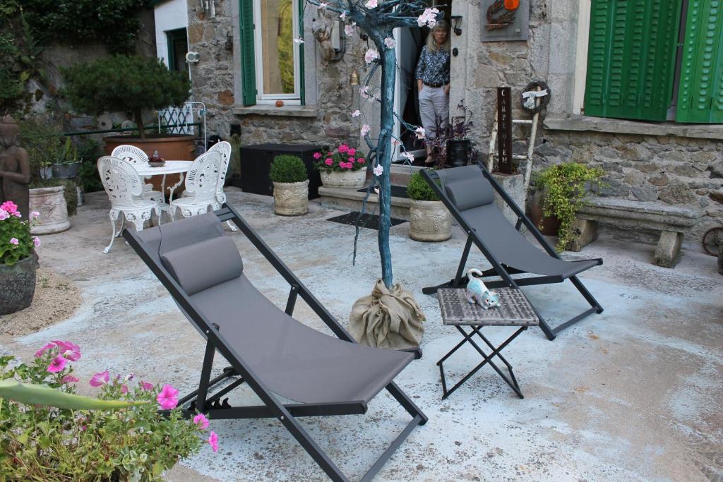two chairs and an umbrella in a yard at Chambre Bounty cuisine privée, salle d&#39;eau, terrasse, garage in Olliergues