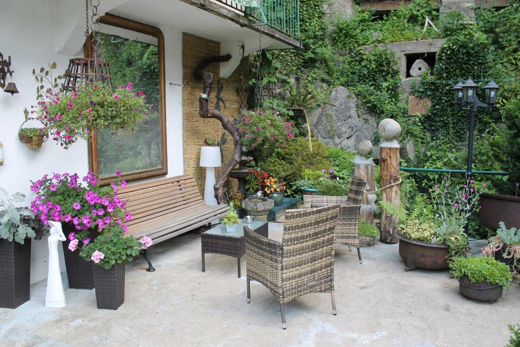 a patio with a bench and a table with flowers at Chambre Bounty cuisine privée, salle d&#39;eau, terrasse, garage in Olliergues
