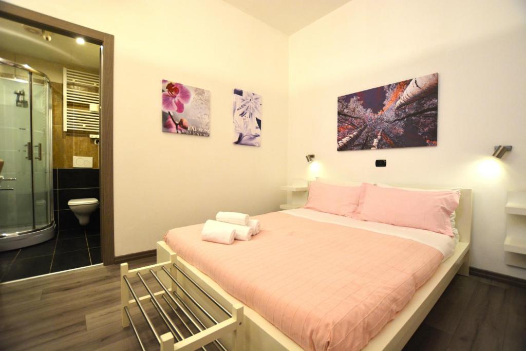 シルミオーネにあるHarmony Sirmione - Affitti Brevi Italiaのベッドルーム1室(ピンクの枕が付いた大型ベッド1台付)