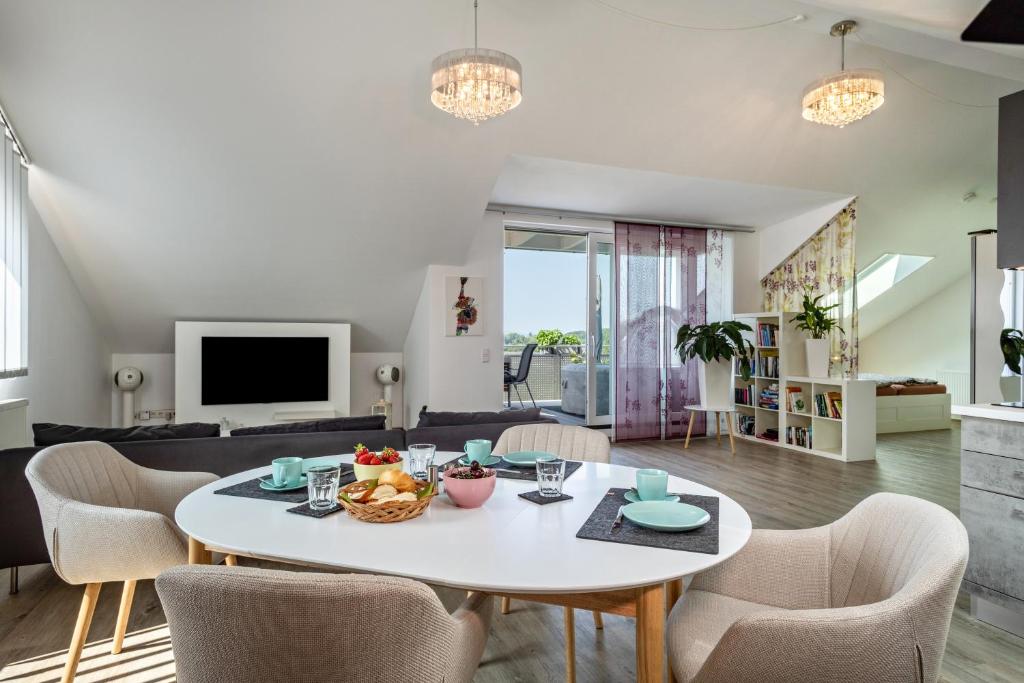a living room with a table and chairs at Loft Schwenck in Kressbronn am Bodensee
