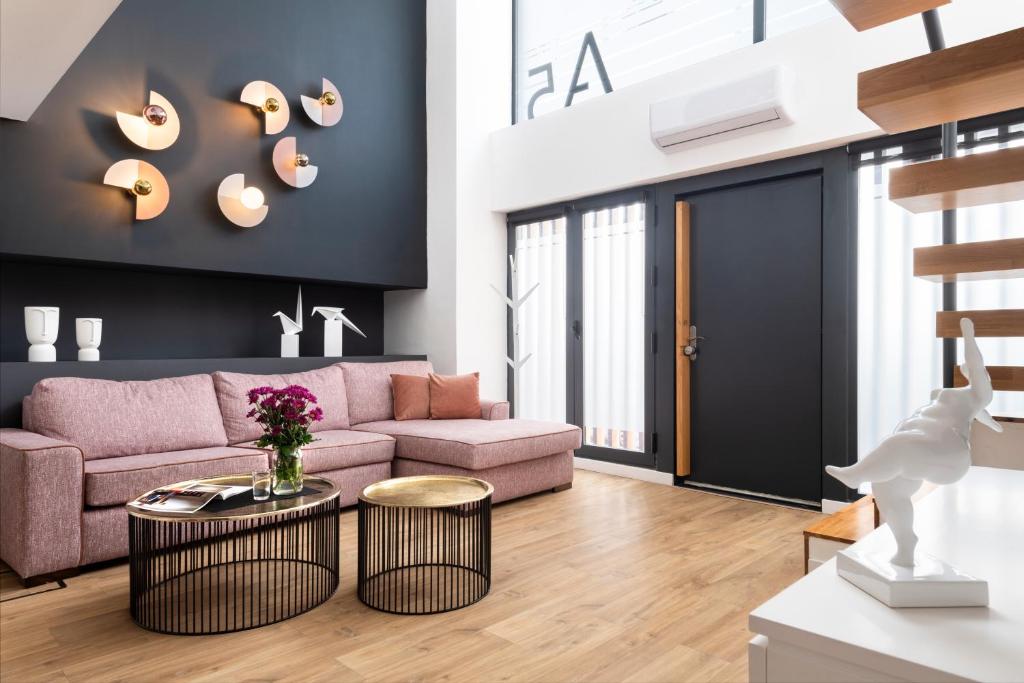 a living room with a pink couch and a table at Murillo Gardens Sevilla by Magno Apartments in Seville