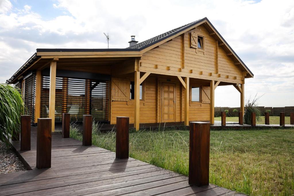 a small wooden cabin with a wooden deck at Domek Całoroczny Powidz tel 512-589-997 in Powidz