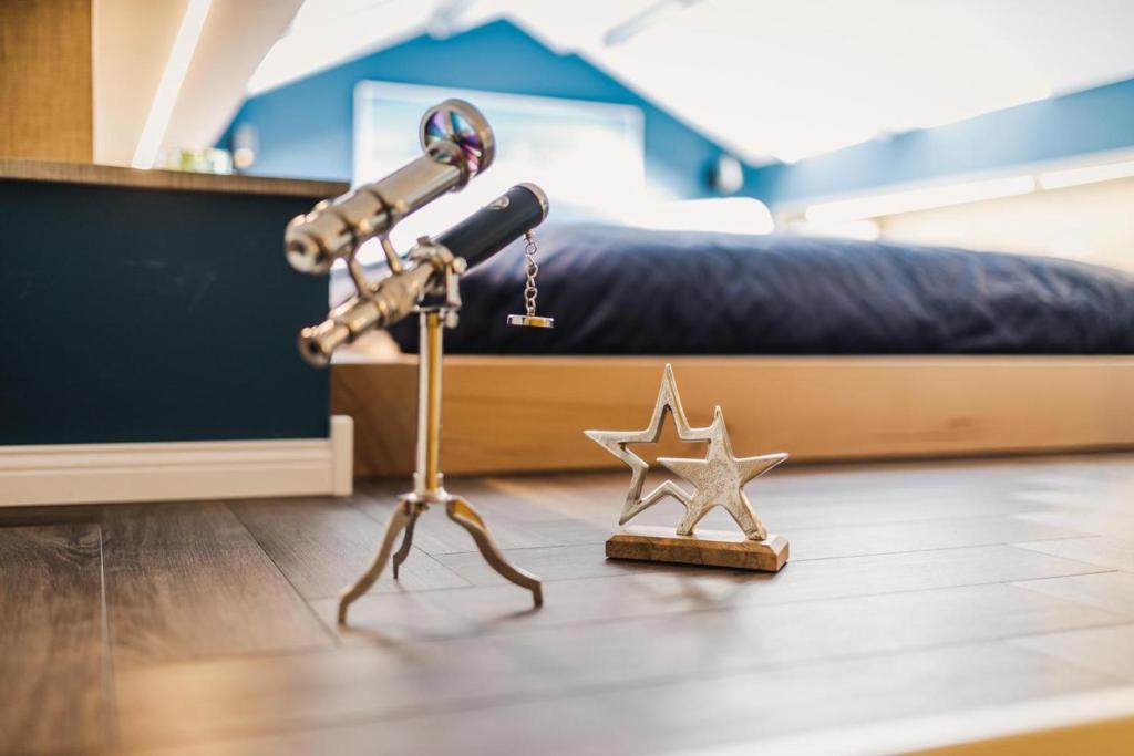 a telescope and a star next to a bed at Ferienwohnung "SteernKieker" - komfortabel und modern! in Klausdorf Mecklenburg Vorpommern