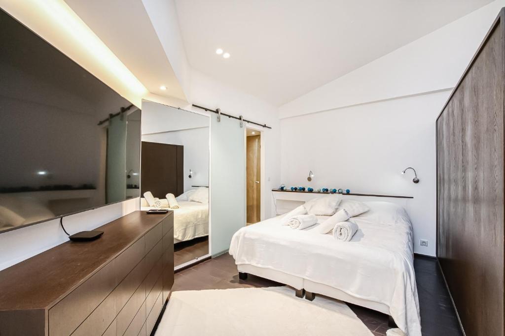 Un dormitorio con una cama y un espejo grande. en Appartement Place des lices avec Parking, en Saint-Tropez