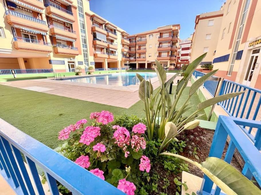 een balkon met roze bloemen en een zwembad bij Apartamento Paraíso del Sol in Torrox Costa