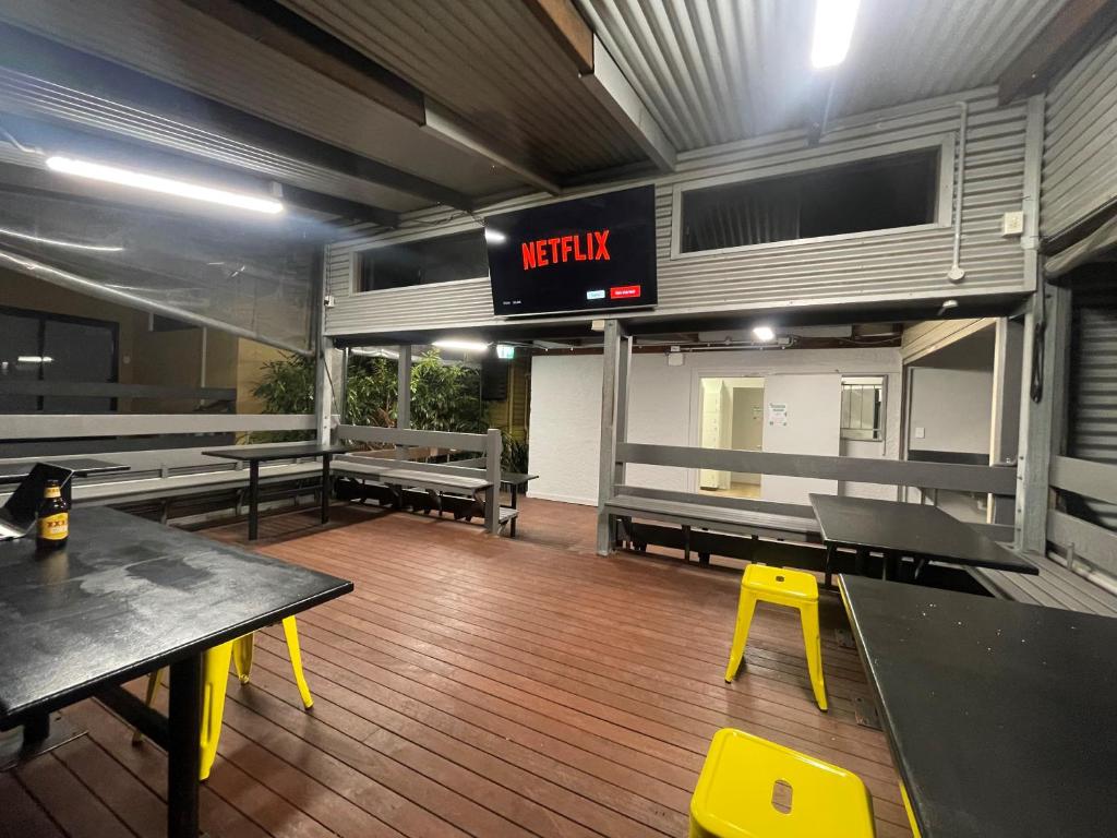 um restaurante com mesas e bancos e uma placa que diz respawn em Banana Backpackers em Brisbane