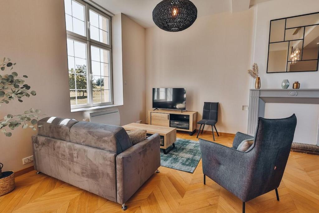a living room with a couch and a tv at Domaine Grand Piquecaillou - Appartement Pessac Leognan 
