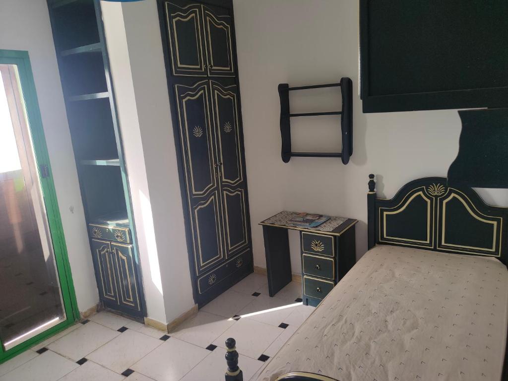 a bedroom with two doors and a bed and a table at Jardine Al Andalous in Tangier