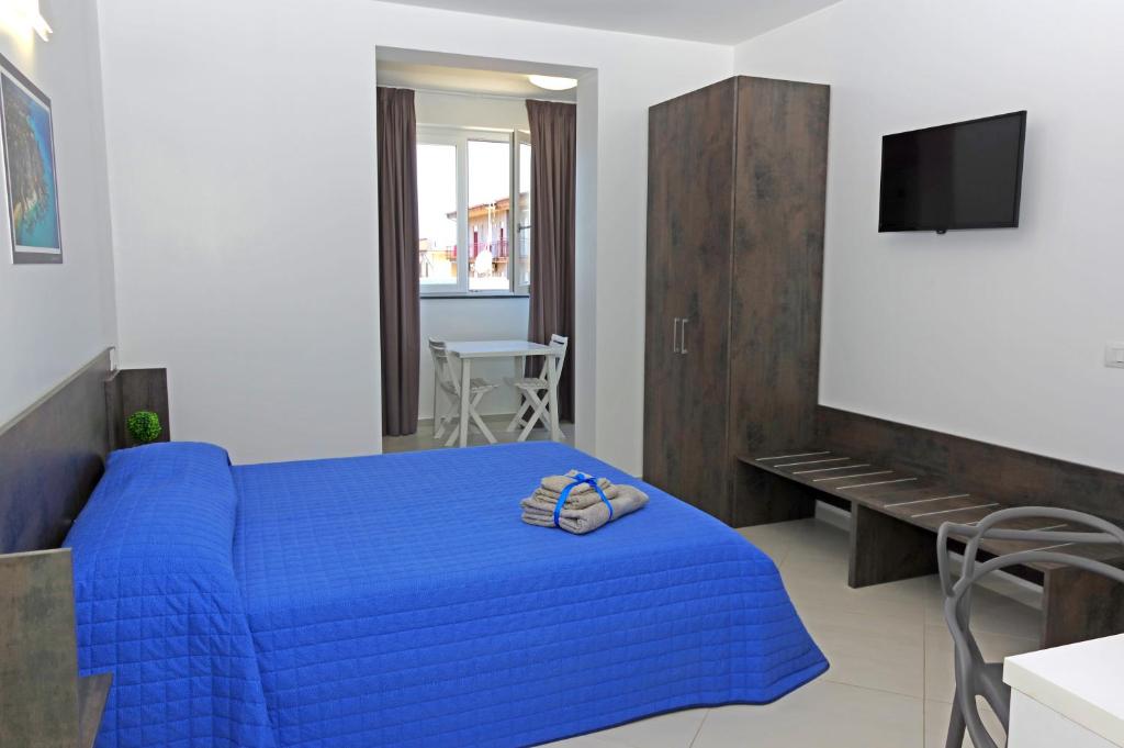 ein Schlafzimmer mit einem blauen Bett und einem TV in der Unterkunft GEMMA DEI 2 MARI in Cinquefrondi