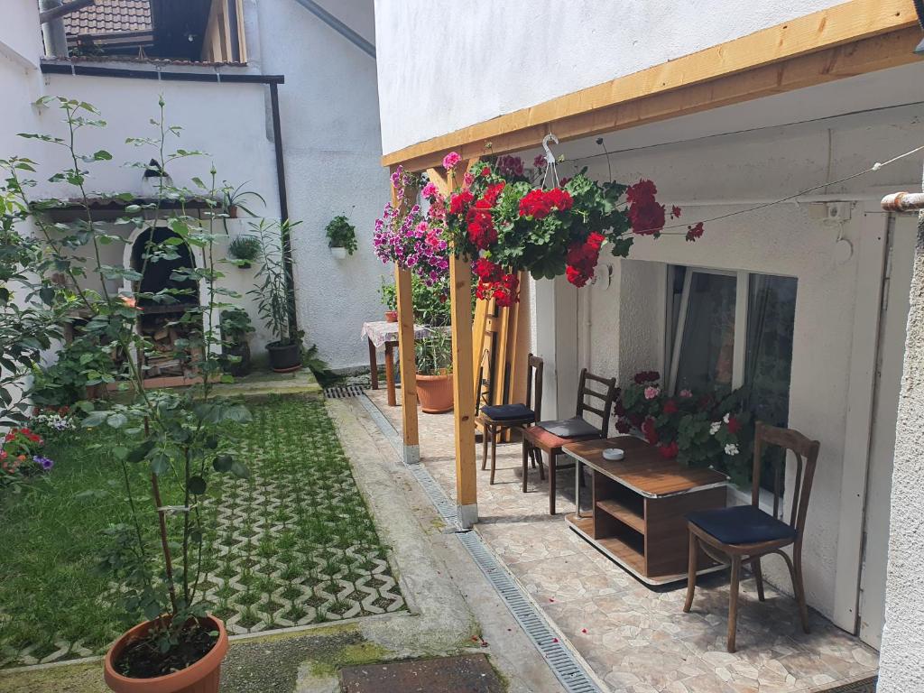 een patio met een tafel, stoelen en bloemen bij Carissa House in Braşov