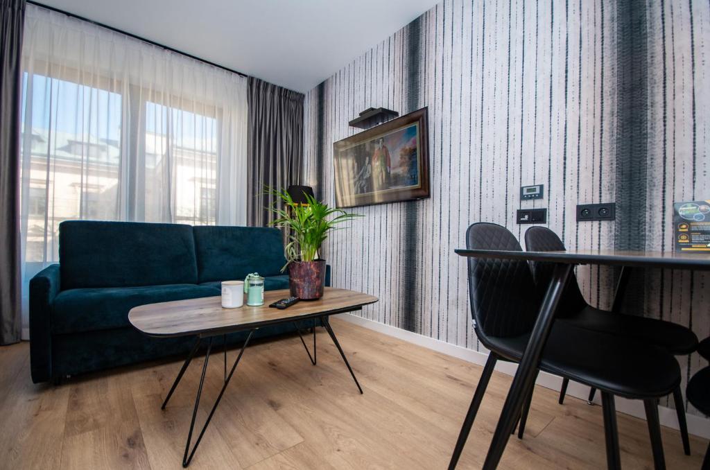 uma sala de estar com um sofá verde e uma mesa em Aparthotel InPoint Cracow G15 - Free Underground Parking em Cracóvia