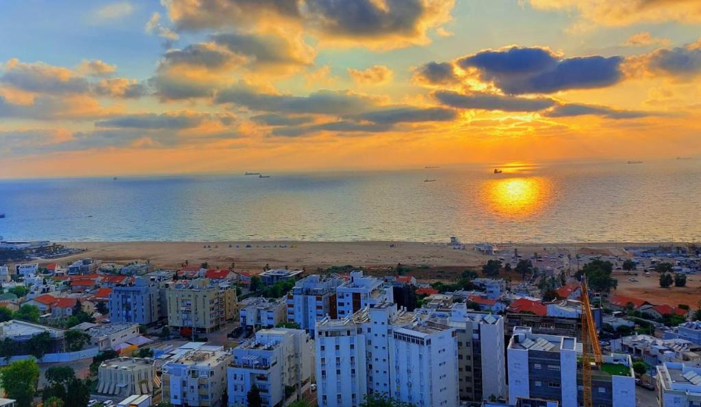 - une vue sur la plage et l'océan au coucher du soleil dans l'établissement apartments with separate kitchen by the sea, à Ashdod