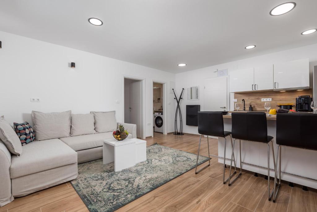 a living room with a couch and a kitchen at Apartment City Peace in Rijeka