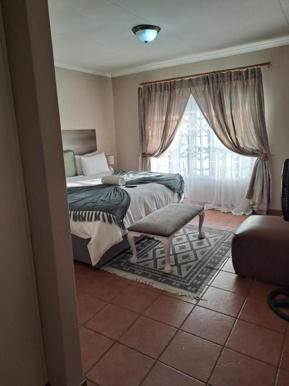 a bedroom with two beds and a window at Courtlyguesthouse in eMalahleni