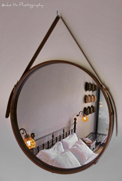 a mirror reflecting a bed with white pillows at Niriides Luxury Apartments in Syvota
