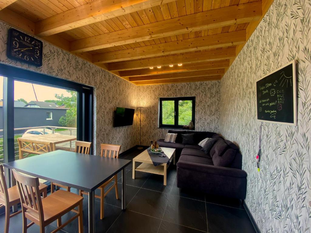 een woonkamer met een tafel en een bank bij Ferienwohnung am Weiher Kategorie 1 in Nideggen