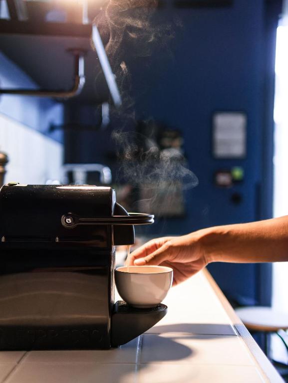 a person is putting a bowl into a toaster at Deskopolitan House in Paris