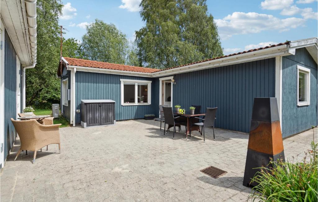 a patio with a table and chairs and a blue building at 2 Bedroom Gorgeous Home In Vordingborg in Vordingborg