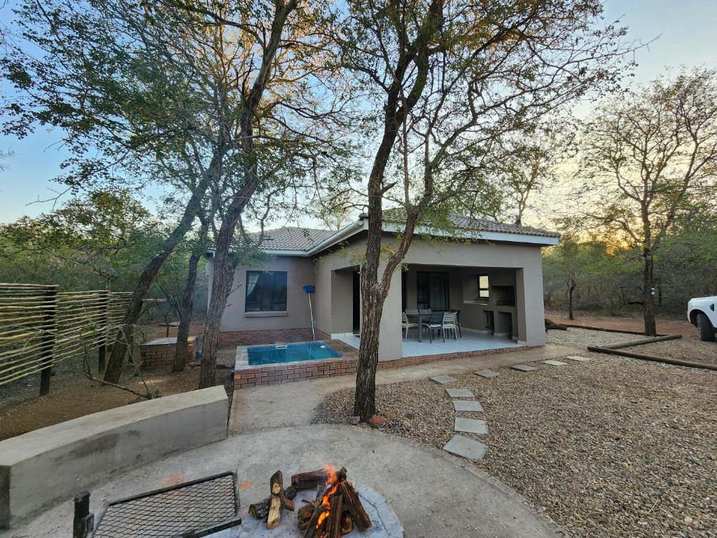 a house with a fire pit in front of it at 3714 @Ribbok in Marloth Park