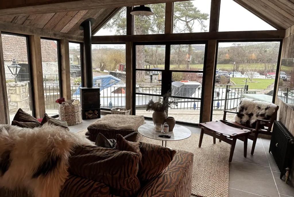 uma sala de estar com um sofá e uma grande janela em Riverside 2 Bed Cabin With Paddle Boards & Bikes em Bristol