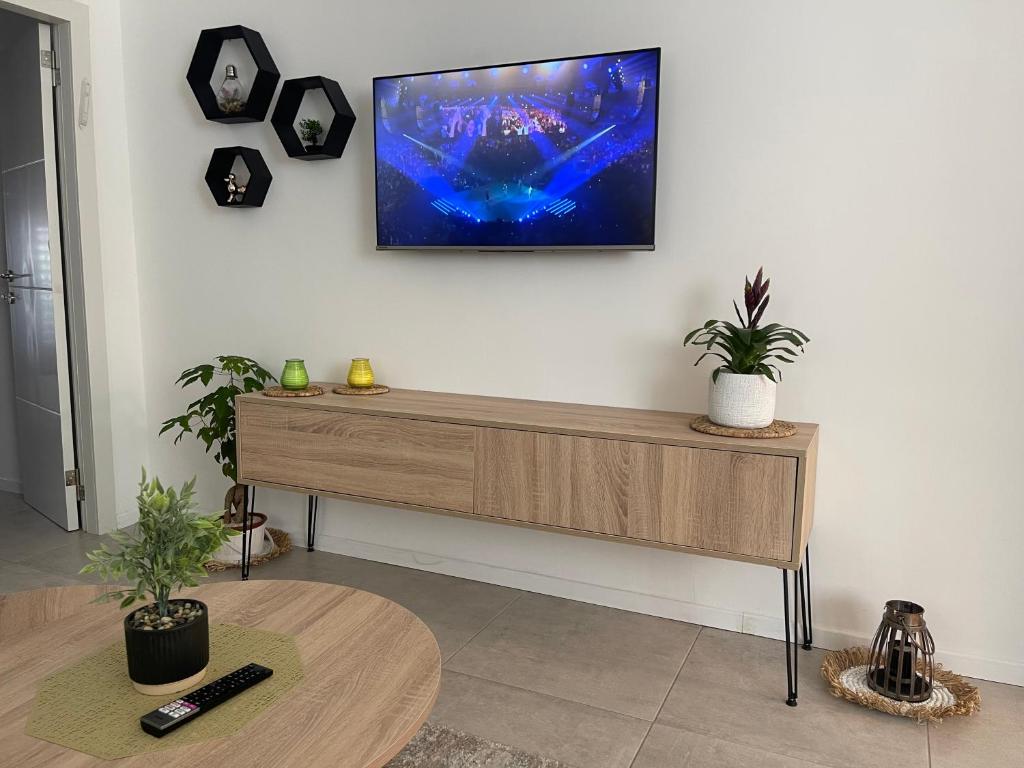 uma sala de estar com uma televisão na parede em Good vibes house em Rehovot