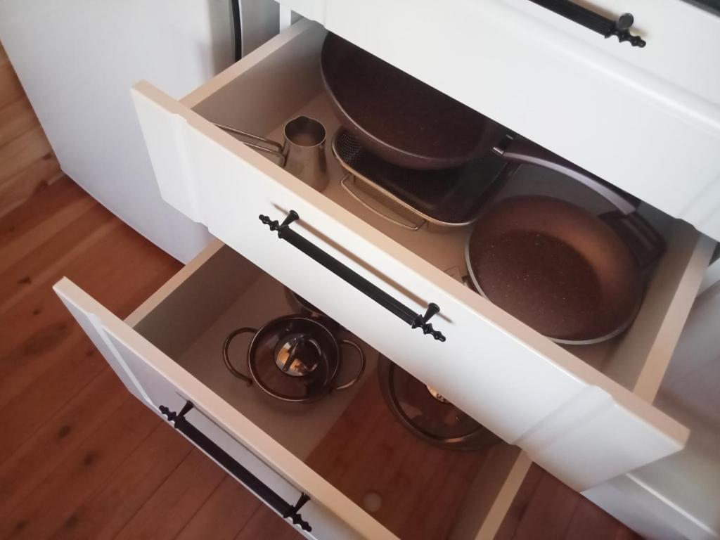 an open kitchen drawer with pots and pans in it at Yildiz Ahşap Evleri in Datca