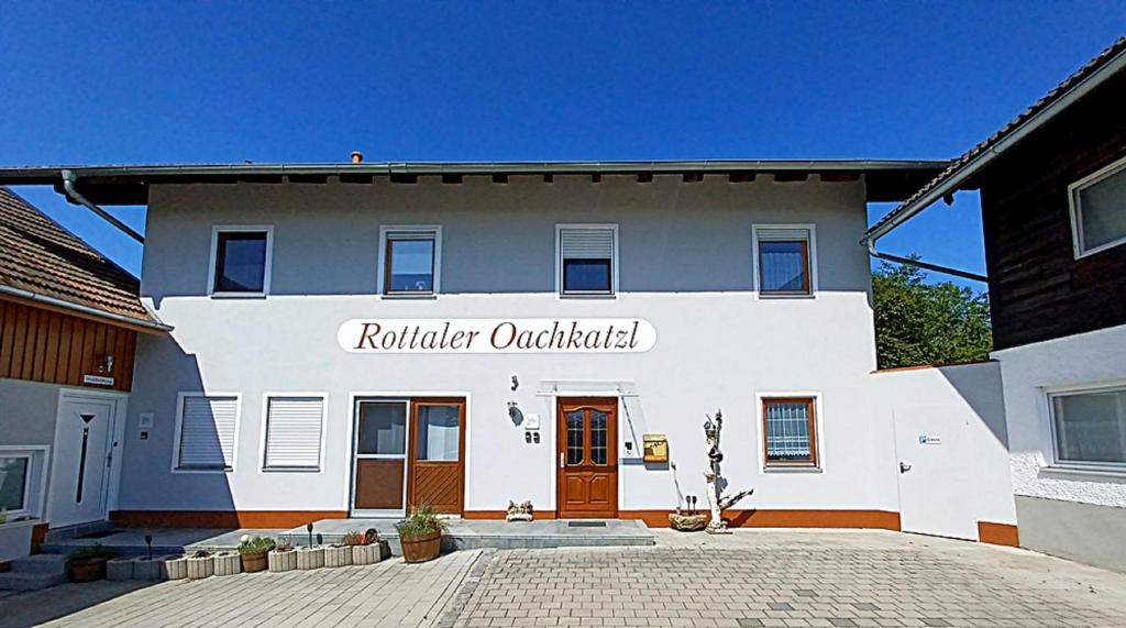 a white building with a sign that reads rutherford orchestration at Rottaler Ferienhaus - Rottaler Oachkatzl in Roßbach