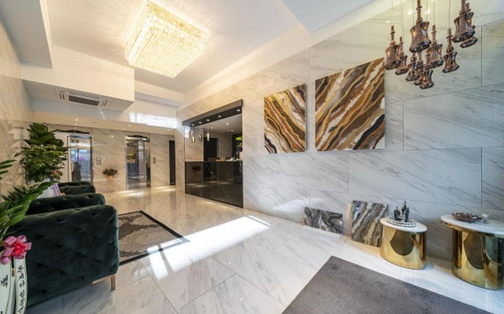 a lobby with a black couch and marble walls at KNox Hotel in Cheonan