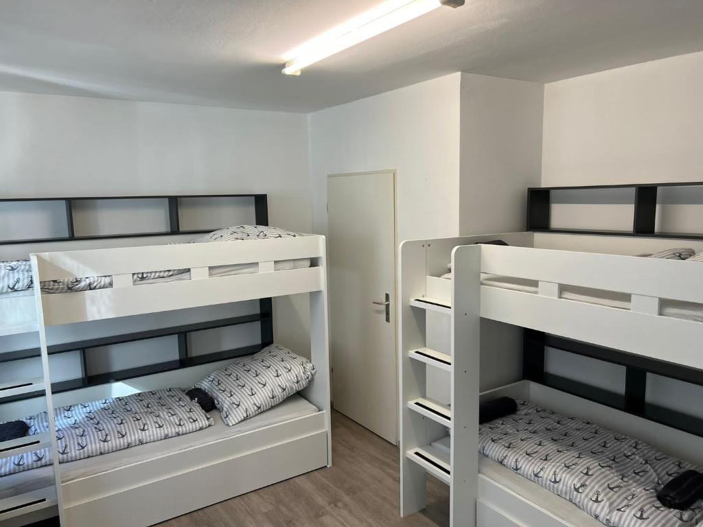 a small room with three bunk beds in it at Cityapartment24 bei Hauptbahnhof in Bremen