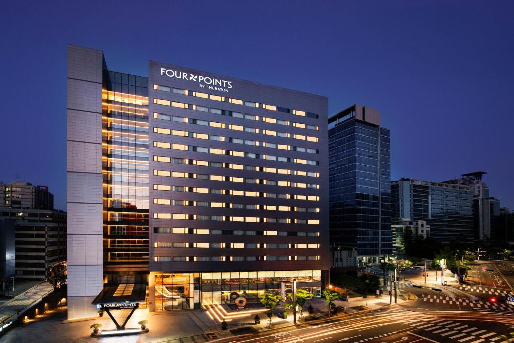 un edificio alto con un cartel en una ciudad en Four Points by Sheraton Seoul, Guro en Seúl