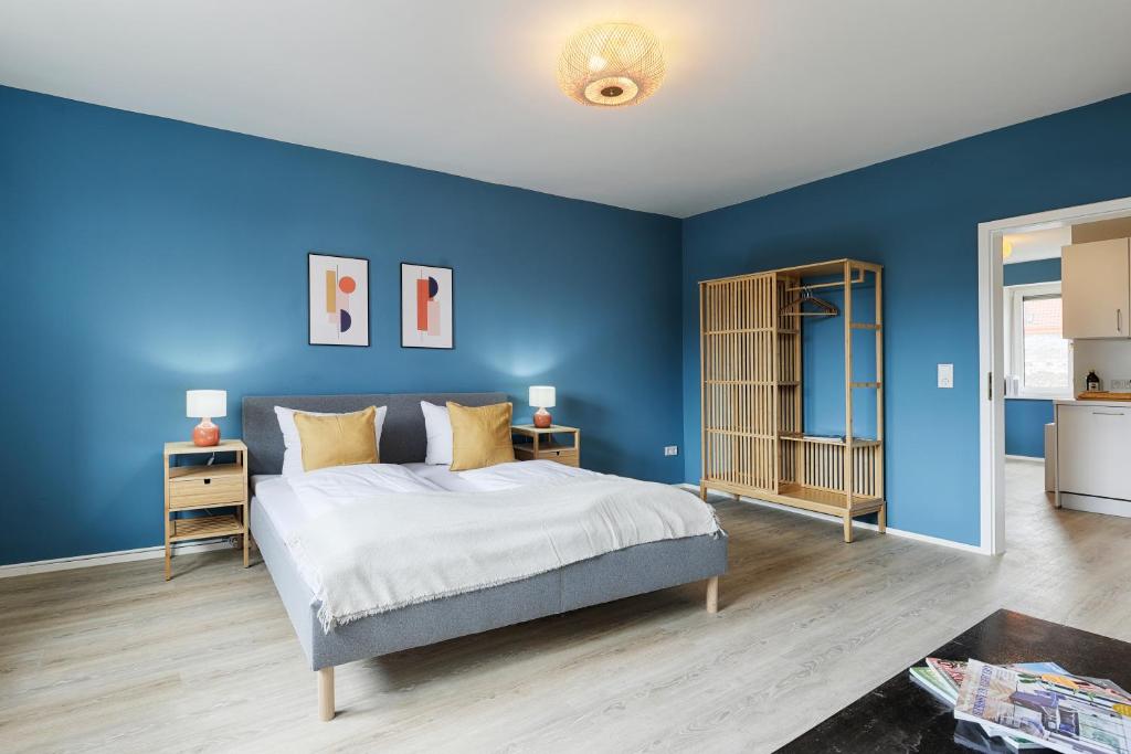 a blue bedroom with a bed and blue walls at Fewos am Main mit Dachterrasse & Fahrradgarage - by homekeepers in Ochsenfurt