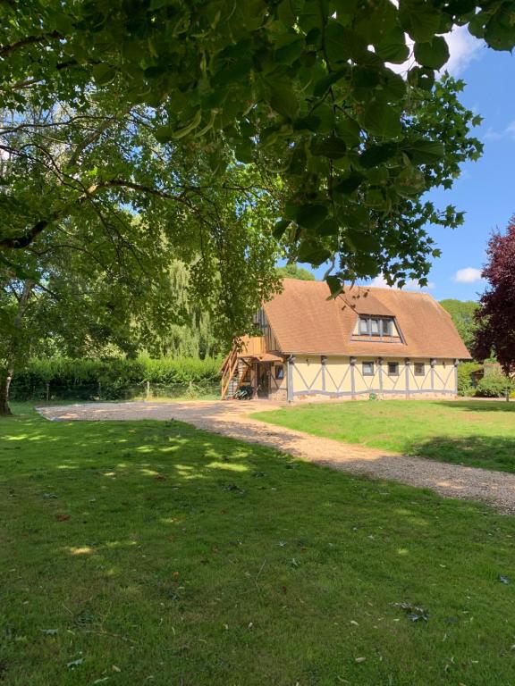 a barn with a tractor in front of a house at Chambre à la campagne in Hauville