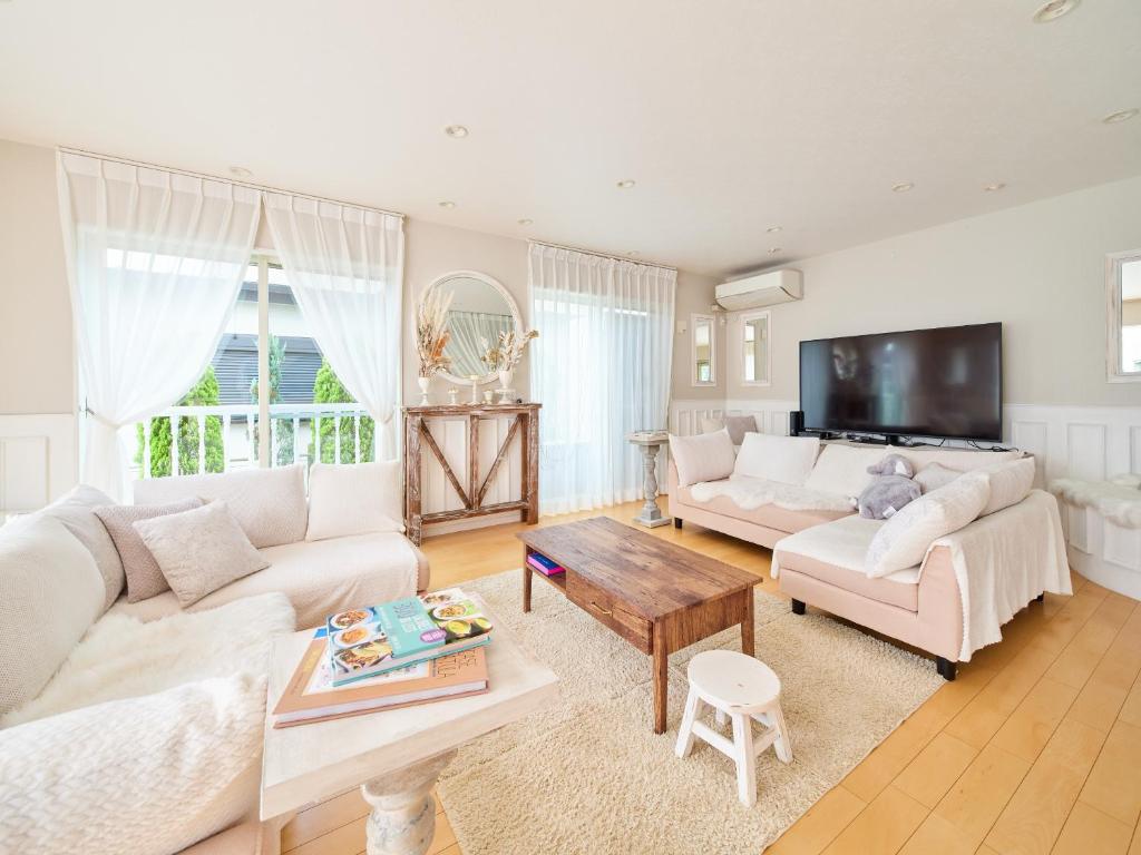 sala de estar con muebles blancos y TV en Villa OLIVE Sajima -佐島の丘- ペット可 en Yokosuka