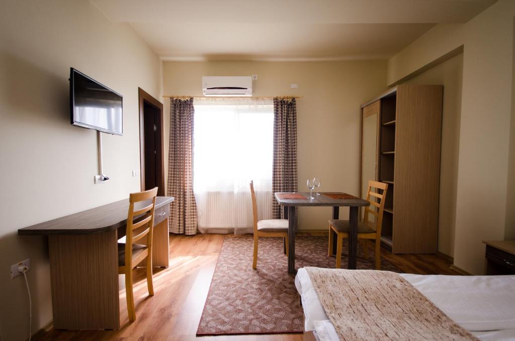 クルジュ・ナポカにあるApart Hotel Bonjour Clujのテーブルとダイニングルームが備わる客室です。