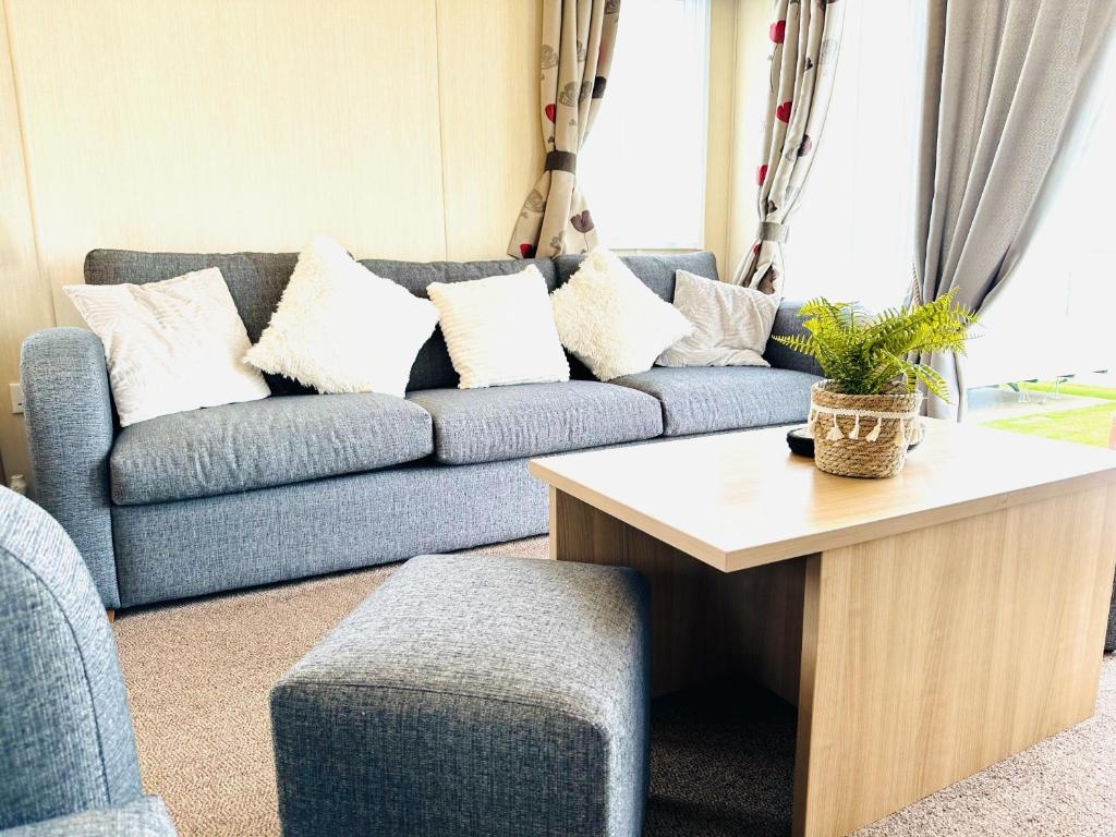 a living room with a blue couch with white pillows at Cosy Corner in Filey