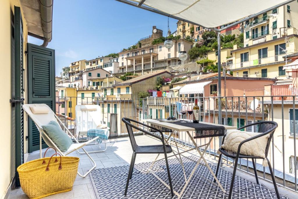 a balcony with a table and chairs on a balcony at WanderJohn penthouse 5terreparco in Riomaggiore